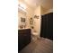 Bathroom with dark-stained vanity, framed art, soft lighting, and shower-tub combo with black curtain at 9348 Lantana Trl, Jonesboro, GA 30238