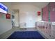 Bright Bedroom with vaulted ceilings, featuring a pink accent wall and a crib at 9348 Lantana Trl, Jonesboro, GA 30238