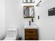 Small but well-appointed bathroom with wood vanity, modern fixtures, and a wall mirror at 1377 Marston St, Smyrna, GA 30080