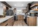 Modern kitchen with stainless steel appliances, a center island, and floating wooden shelves at 1377 Marston St, Smyrna, GA 30080