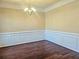 Elegant dining room with wainscoting, crown molding, and stylish chandelier at 2478 Brynfield Cv, Suwanee, GA 30024