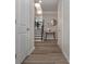 Hallway with wood-look floors, white trim, and neutral walls, leading to stairs and other rooms at 2871 Fareed, Douglasville, GA 30135