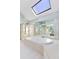 Bright bathroom featuring a skylight, large tub, glass shower, and mirrored wall at 3311 Fieldwood Se Dr, Smyrna, GA 30080