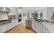 Bright kitchen features white cabinets, stainless steel appliances, and hardwood floors, with a view to the eating area at 3311 Fieldwood Se Dr, Smyrna, GA 30080