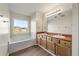 Bright bathroom featuring double sink vanity and a tub by the window at 5538 Cascade Sw Rdg, Atlanta, GA 30336