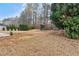 Expansive backyard with a wooden playhouse set among mature trees and a landscape with dormant grass at 675 Timber Ives Dr, Dacula, GA 30019