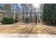 Large backyard features a playset and mature trees, offering a spacious outdoor area at 675 Timber Ives Dr, Dacula, GA 30019