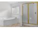 Bathroom with windowed tub, and tiled flooring complemented by a glass-enclosed shower at 675 Timber Ives Dr, Dacula, GA 30019