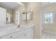 Bright bathroom featuring a double sink vanity, large mirror and window at 675 Timber Ives Dr, Dacula, GA 30019