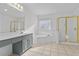 Bathroom with double sinks, windowed tub, and tiled flooring complemented by a glass-enclosed shower at 675 Timber Ives Dr, Dacula, GA 30019
