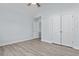 Cozy bedroom features neutral paint, light-colored wood flooring, and double doors at 675 Timber Ives Dr, Dacula, GA 30019