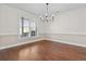 Bright dining room features hardwood floors, natural light from large window, and elegant chandelier at 675 Timber Ives Dr, Dacula, GA 30019