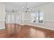 Elegant dining room featuring hardwood floors and a decorative chandelier with natural light from a large window at 675 Timber Ives Dr, Dacula, GA 30019