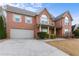 Charming two-story brick home featuring an attached garage, a welcoming front porch, and neat landscaping at 675 Timber Ives Dr, Dacula, GA 30019