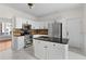 Bright kitchen features white cabinets, stainless steel appliances, and a center island with a black countertop at 675 Timber Ives Dr, Dacula, GA 30019