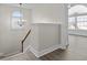 Upstairs landing with modern chandelier, view of a sunroom, and hardwood flooring at 675 Timber Ives Dr, Dacula, GA 30019