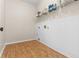 Functional laundry room with laminate wood flooring, white-painted beadboard, and storage shelving at 675 Timber Ives Dr, Dacula, GA 30019