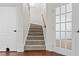 Carpeted stairs with a wood railing lead to the upper level, adjacent to a glass-paned door at 675 Timber Ives Dr, Dacula, GA 30019