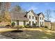Elegant two-story painted-brick home with manicured lawn, creating a stately curb appeal and park-like setting at 2115 Azalea Dr, Roswell, GA 30075