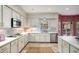 Well-lit kitchen showcasing white cabinets, quartz countertops, stainless steel appliances, and a patterned backsplash at 2115 Azalea Dr, Roswell, GA 30075