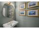 Elegant powder room featuring modern fixtures, stylish wall decor, and a sleek pedestal sink at 2115 Azalea Dr, Roswell, GA 30075