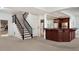 Finished basement with stairs, dark wood bar with granite countertops, and carpeted floor at 9185 Old Southwick Pass, Johns Creek, GA 30022
