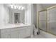 Bathroom featuring a vanity with a large mirror, updated fixtures, and a shower with a glass door at 9185 Old Southwick Pass, Johns Creek, GA 30022