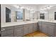 Spacious bathroom featuring double sinks, a large mirror, gray cabinets, hardwood floors, and a separate shower at 9185 Old Southwick Pass, Johns Creek, GA 30022