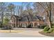 Elegant brick home with a circular driveway and meticulously landscaped front yard at 9185 Old Southwick Pass, Johns Creek, GA 30022