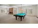 Spacious game room with a brick fireplace and pool table under a decorative chandelier at 9185 Old Southwick Pass, Johns Creek, GA 30022