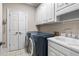 Well-equipped laundry room with modern appliances, sink, and storage cabinets at 9185 Old Southwick Pass, Johns Creek, GA 30022