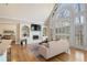 Inviting living room featuring a fireplace, built-in shelves, and a large arched window at 9185 Old Southwick Pass, Johns Creek, GA 30022