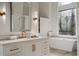 This main bathroom features white cabinets with gold hardware, a freestanding tub and a beautiful window at 9185 Old Southwick Pass, Johns Creek, GA 30022