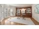 Sunlit home office with custom built-ins, hardwood floors, and large windows at 9185 Old Southwick Pass, Johns Creek, GA 30022