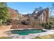 Backyard featuring a luxurious swimming pool, raised patio with elegant brickwork and staircase at 9185 Old Southwick Pass, Johns Creek, GA 30022