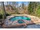 Inviting backyard pool and spa with stone surround and mature trees at 9185 Old Southwick Pass, Johns Creek, GA 30022