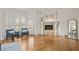 Cozy sitting area with fireplace, hardwood floors, and natural light from shuttered windows and glass door at 9185 Old Southwick Pass, Johns Creek, GA 30022