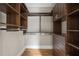 Walk-in closet with custom shelving, drawers, and wooden floors provides ample storage space at 9185 Old Southwick Pass, Johns Creek, GA 30022