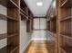 Spacious walk-in closet boasts custom wood shelving and drawers for maximum storage capacity at 9185 Old Southwick Pass, Johns Creek, GA 30022