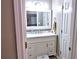 Bright bathroom with a white vanity featuring a marble countertop, classic fixtures, and storage at 1023 Hawk Creek Trl, Lawrenceville, GA 30043