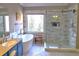 Bathroom with soaking tub, tiled shower, and double sink vanity featuring modern fixtures and a window view at 1023 Hawk Creek Trl, Lawrenceville, GA 30043