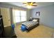 Cozy bedroom with blue walls, carpet, ceiling fan, and a single bed with blue striped bedding at 1023 Hawk Creek Trl, Lawrenceville, GA 30043