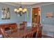 Dining room featuring hardwood table, chairs, chandelier, and wainscoting at 1023 Hawk Creek Trl, Lawrenceville, GA 30043