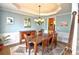 Formal dining room with tray ceiling, hardwood furniture, and wainscoting at 1023 Hawk Creek Trl, Lawrenceville, GA 30043