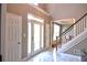 Bright foyer featuring marble floors, a modern staircase, and ample natural light from the front door and transom window at 1023 Hawk Creek Trl, Lawrenceville, GA 30043