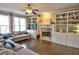 Open living room featuring a fireplace, hardwood floors, built-in bookshelves and a comfy sectional couch at 1023 Hawk Creek Trl, Lawrenceville, GA 30043