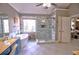 Bright bathroom featuring a glass enclosed shower, garden tub, tile floor, and blue vanity sink at 1023 Hawk Creek Trl, Lawrenceville, GA 30043