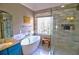 Bright bathroom featuring a glass enclosed shower, garden tub, tile floor, vanity, and bright window at 1023 Hawk Creek Trl, Lawrenceville, GA 30043