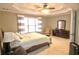 Comfortable main bedroom featuring tray ceilings, carpet, sitting area, dresser and natural light at 1023 Hawk Creek Trl, Lawrenceville, GA 30043