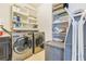 The laundry room is equipped with a washer, dryer, storage shelves, and an ironing board at 2417 Siesta Ct, Marietta, GA 30062